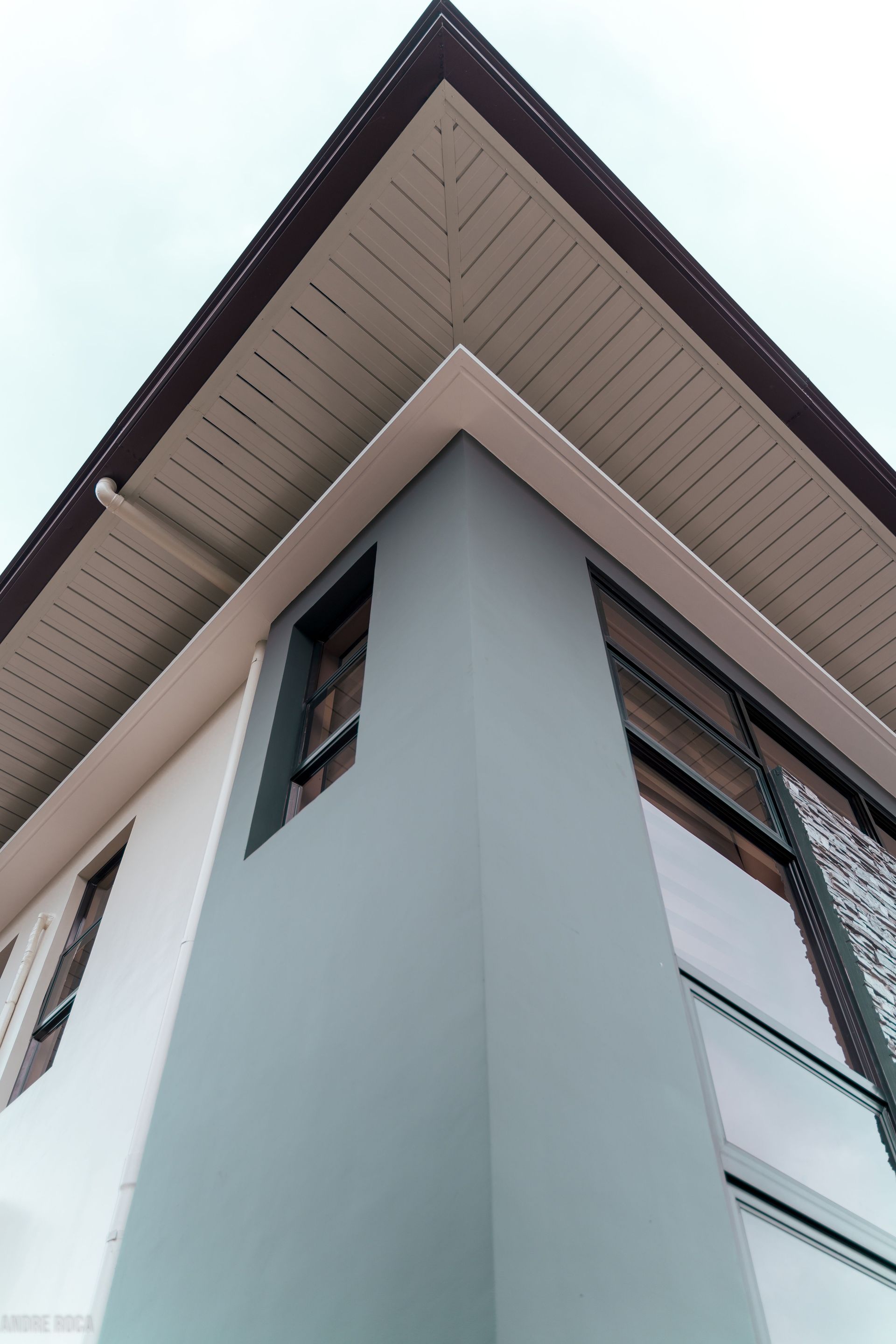 Low-angle view of a modern building facade emphasizing geometric shapes and design elements.
