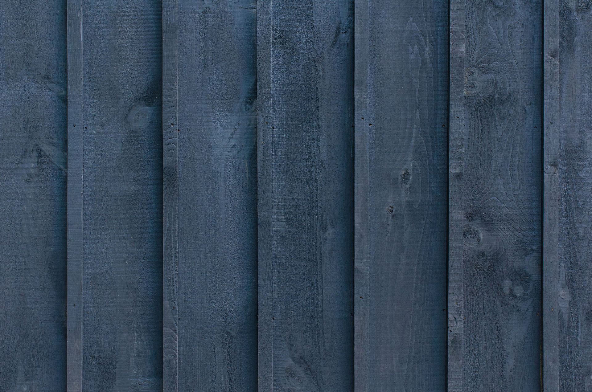 Detailed texture of vertical blue wooden planks in a fence backdrop.
